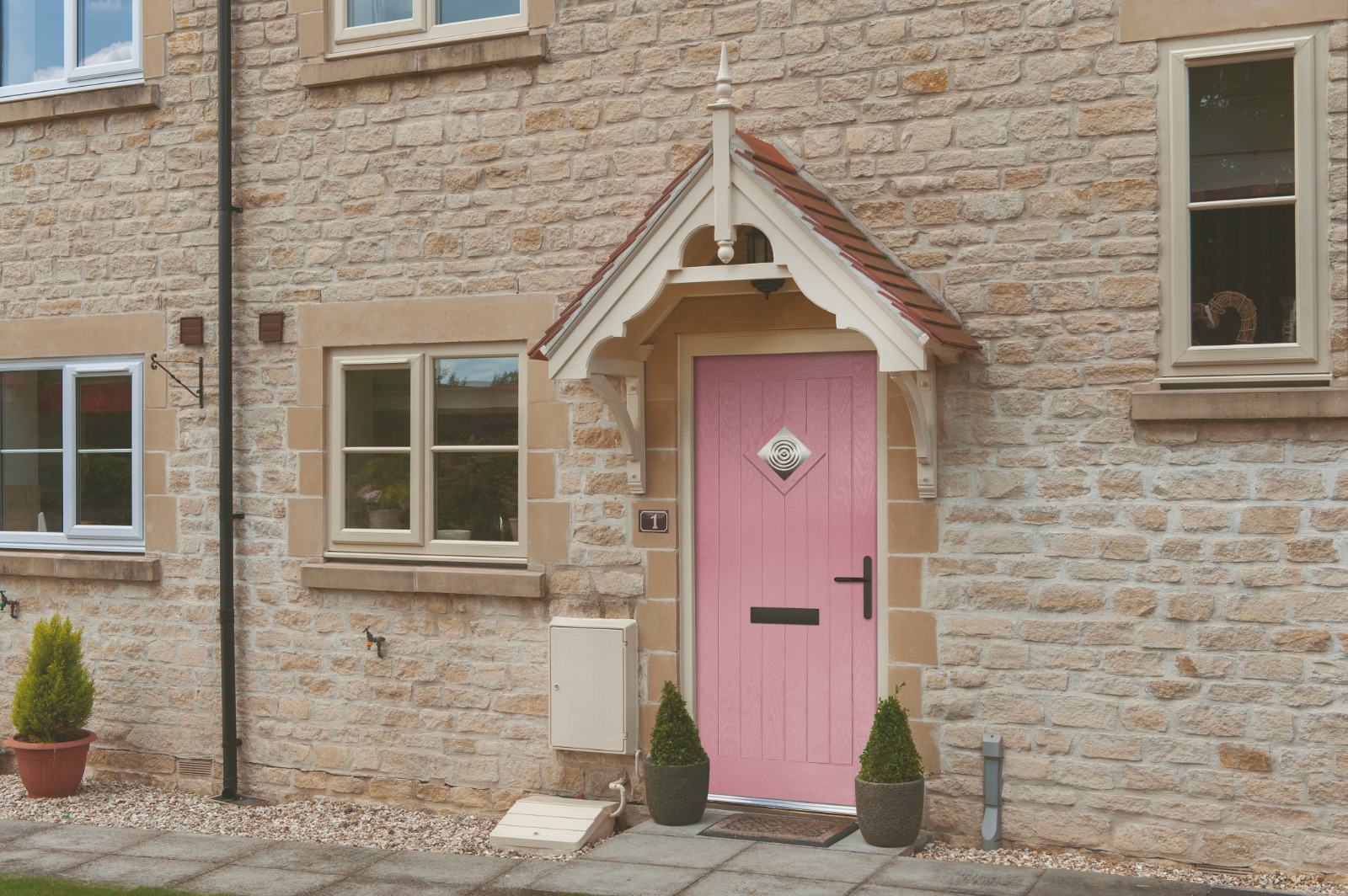 Pink composite front door in a traditional stone porch of a Kent village cottage